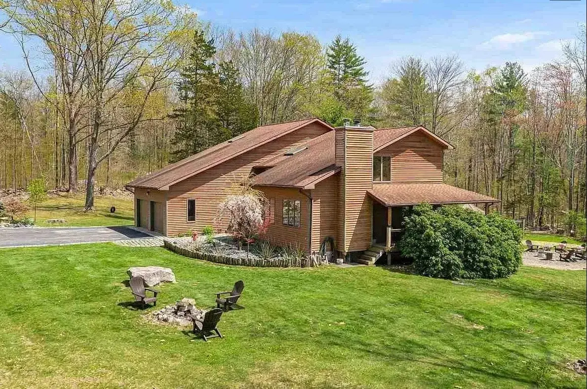 The house from the front lawn, Adirondack chairs on the grass