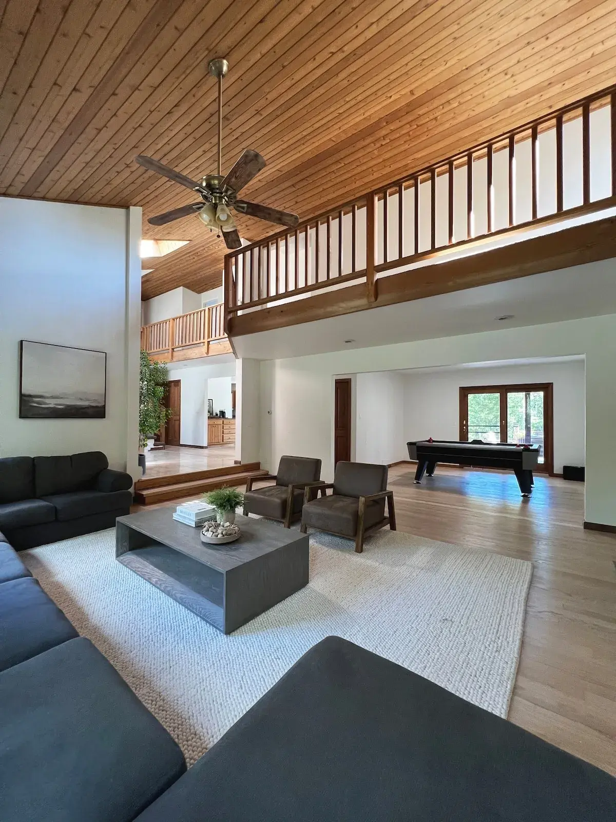 The living room under the balcony, a pool table in the room beyond