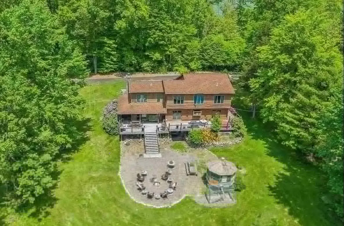 Bird’s-eye view of the house, deck and fire pit among the trees