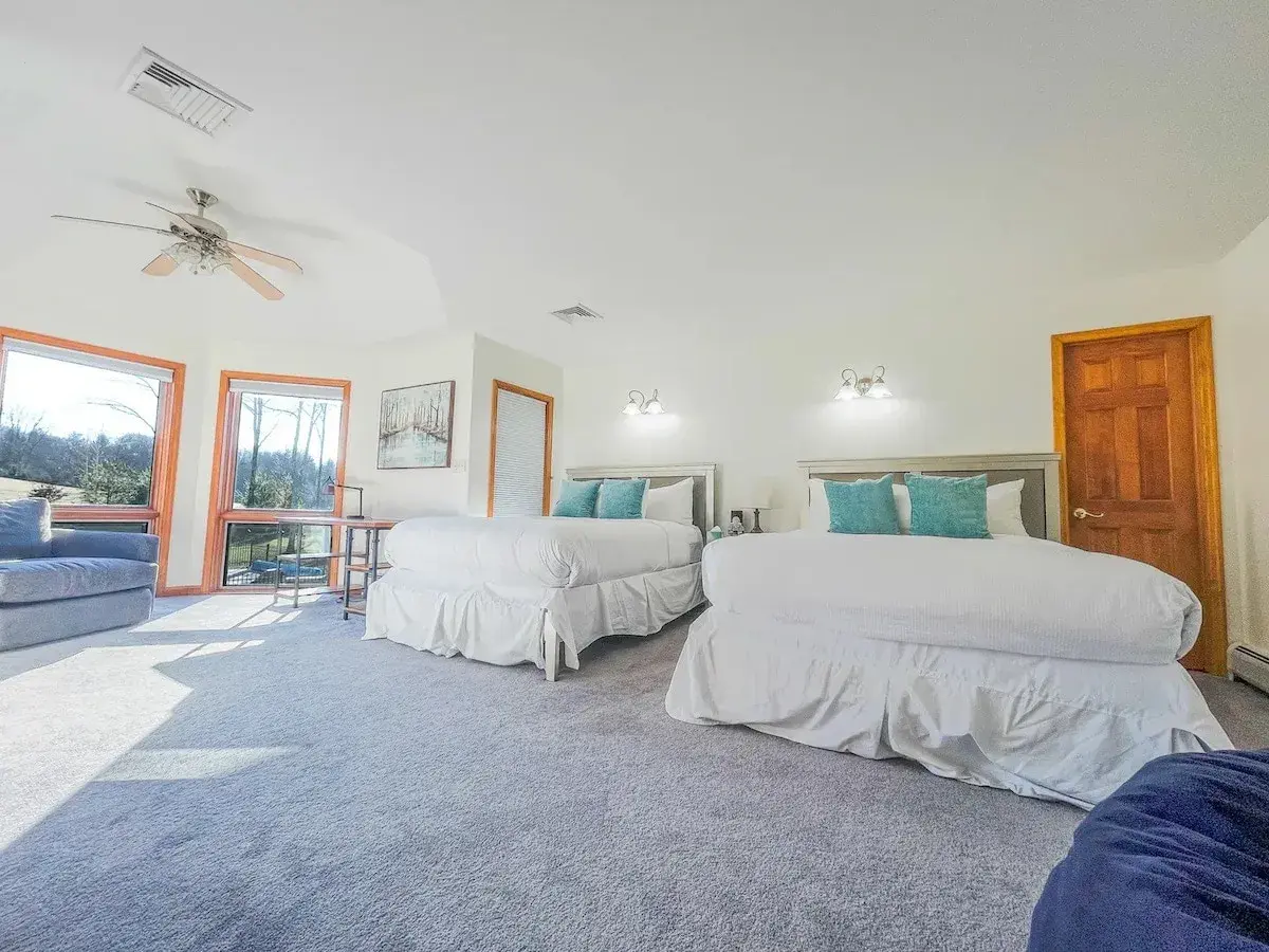 A bedroom with two beds and a view of the lawn