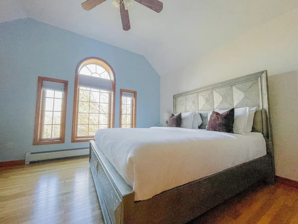 A king bedroom under an arched window