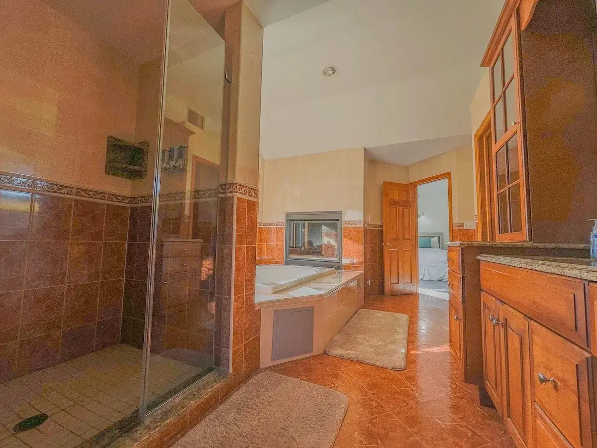 A bathroom with a glass shower and a jetted tub