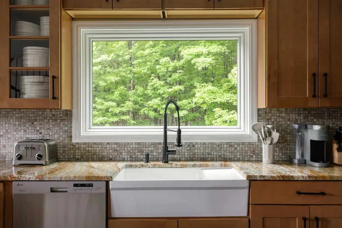 The farmhouse sink under a window to the trees