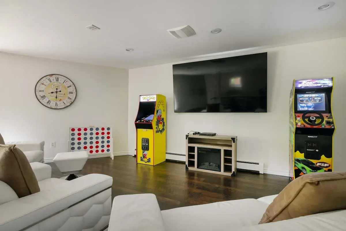 The game room, arcade cabinets and a TV