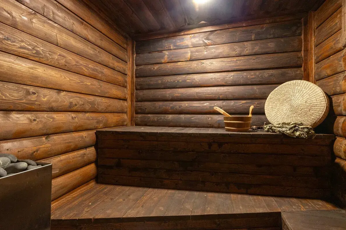 The sauna, log-lined walls and a cedar bench