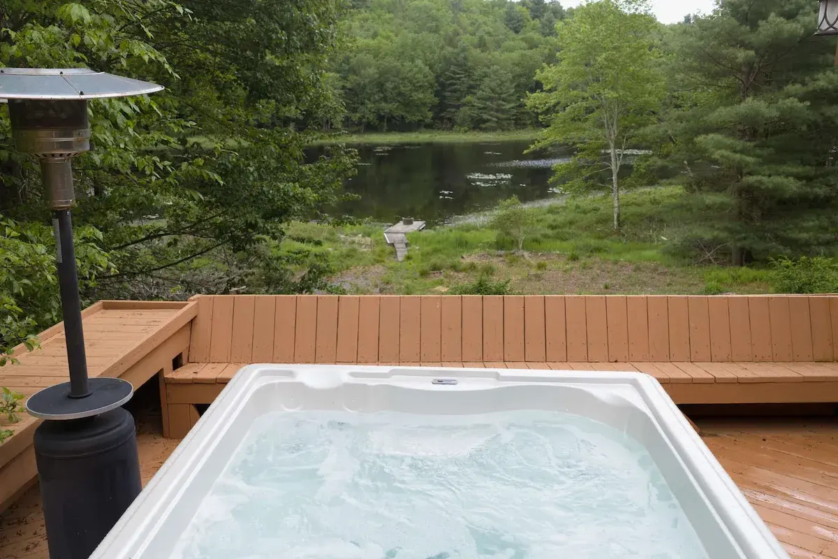 The hot tub on the deck, the lake beyond